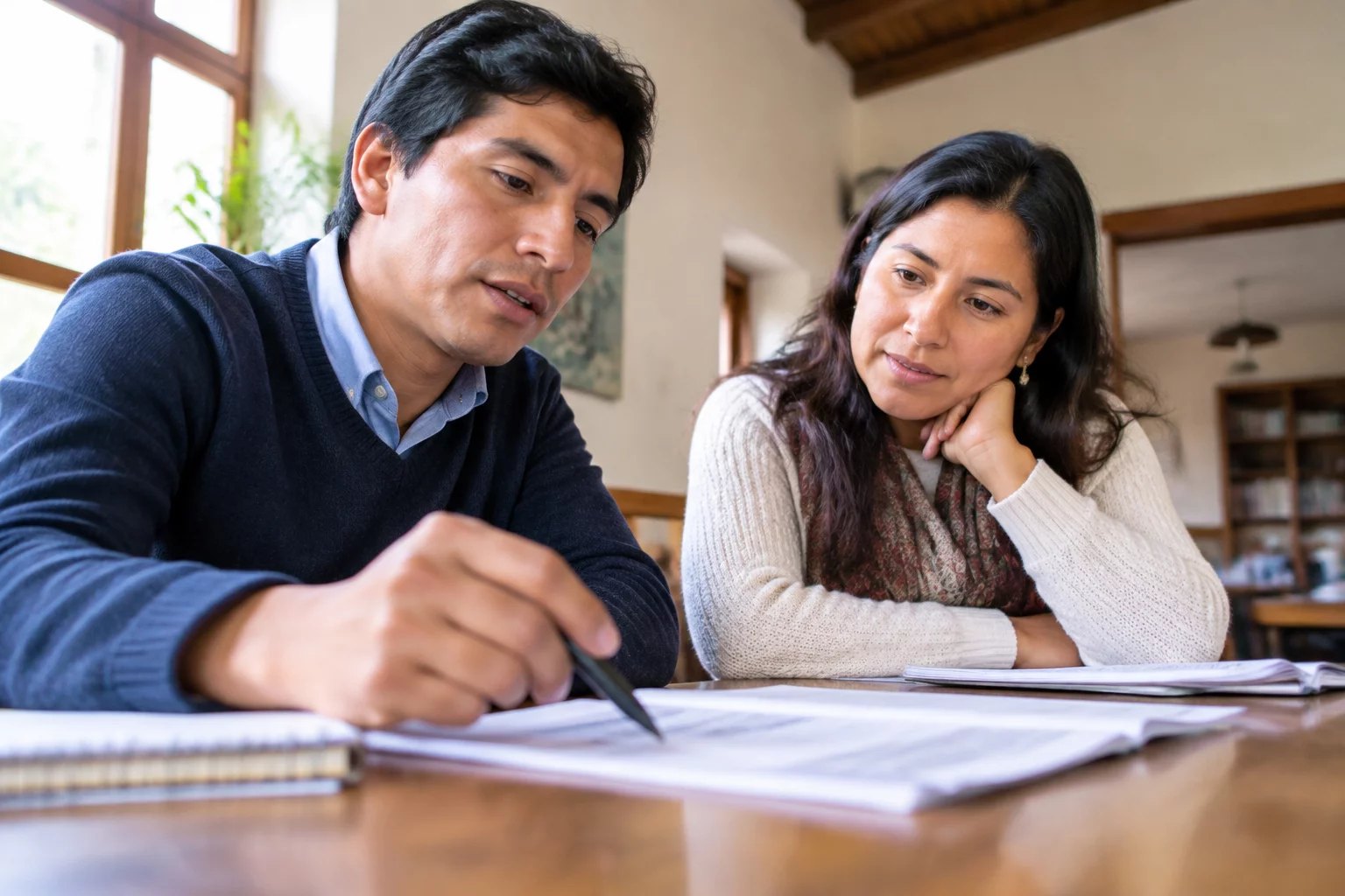 Dos personas revisando apuntes impresos sobre la mesa